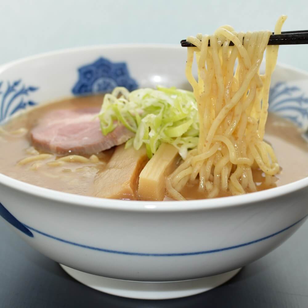 商品名:全粒粉、中加水の中太麺・ストレート麺のとんこつ醤油ラーメンの麺持ち上げ