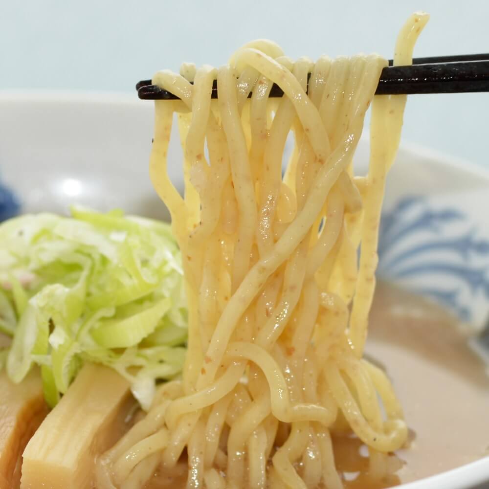 商品名:全粒粉、中加水の中太麺・ストレート麺のとんこつ醤油ラーメンの麺持ち上げアップ