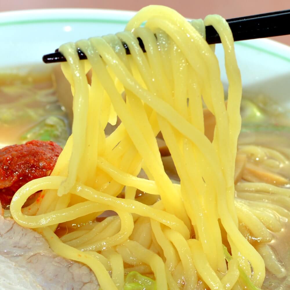 商品名:福寿、多加水 熟成の平打ち太麺・ストレート麺の味噌ラーメンの麺持ち上げアップ