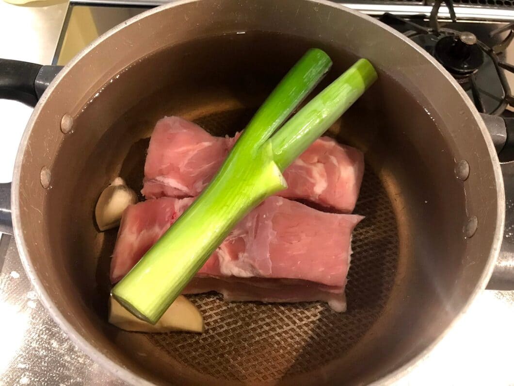 鍋に入れた豚バラ肉とネギ・しょうが